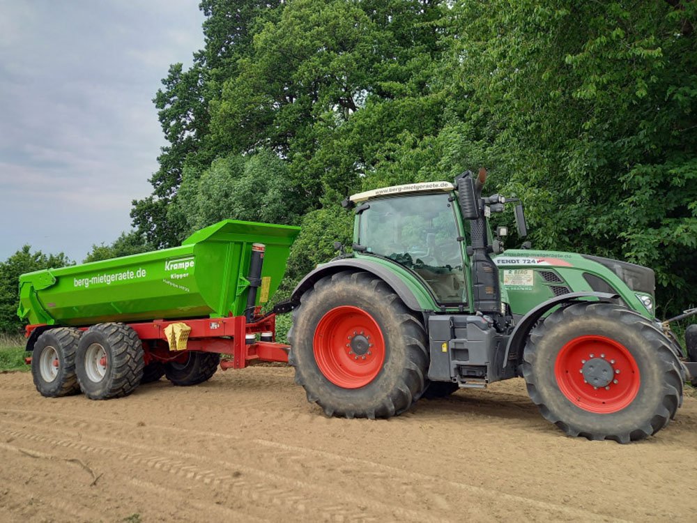 Land- und forstwirtschaftliche Lohnarbeiten Moderner Traktor mit Anhänger bei landwirtschaftlichen Lohnarbeiten